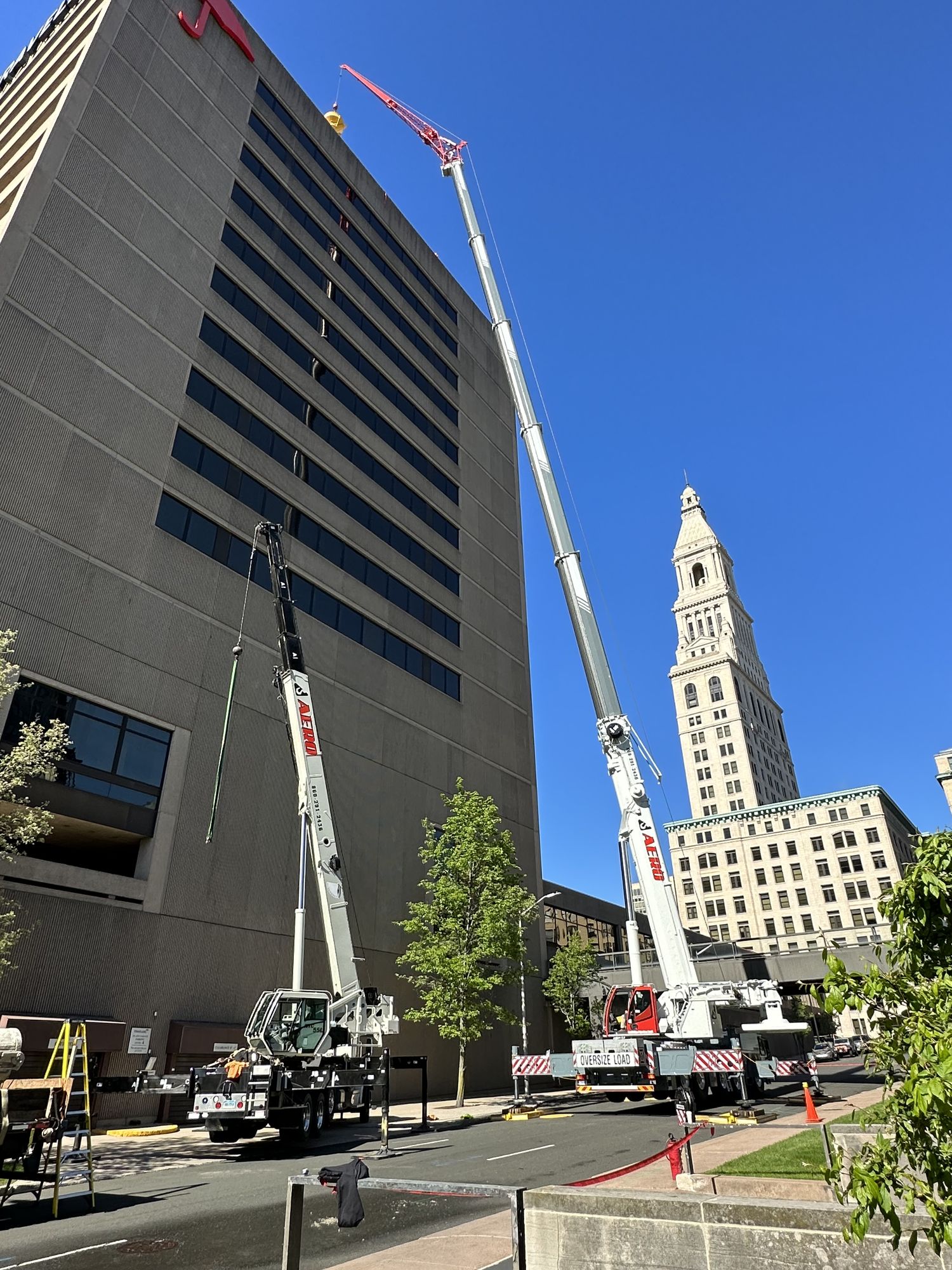 Two Aero cranes coordinating dual-boom lift downtown