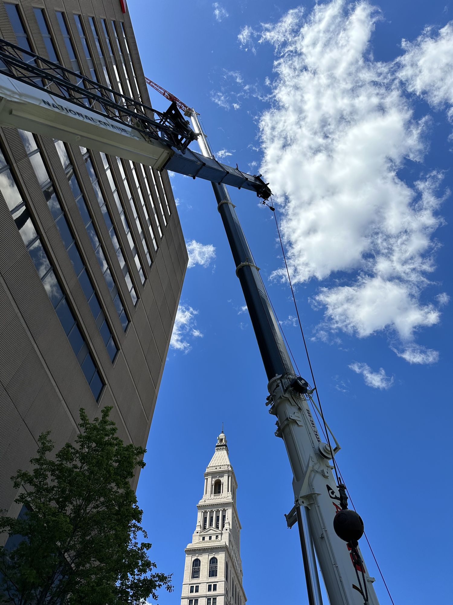 Closeup of crane boom and load at downtown building project
