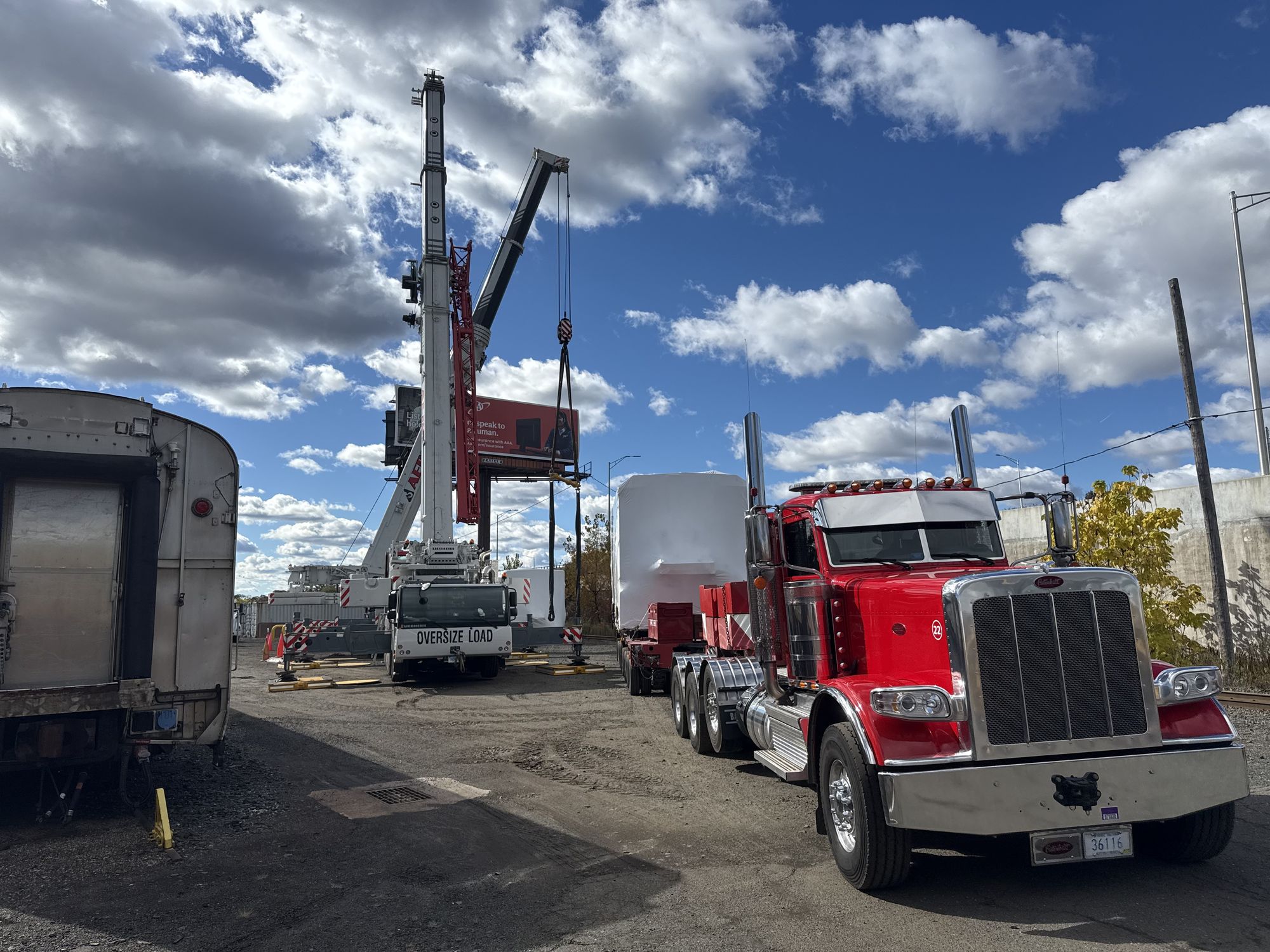 Aero crew coordinating highway sign installation lift