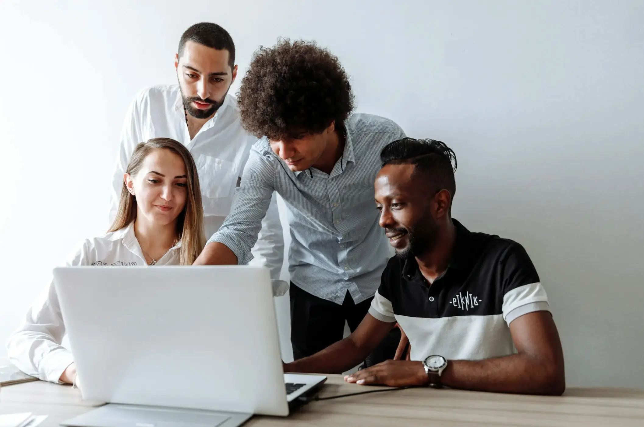 a group of people looking at laptop