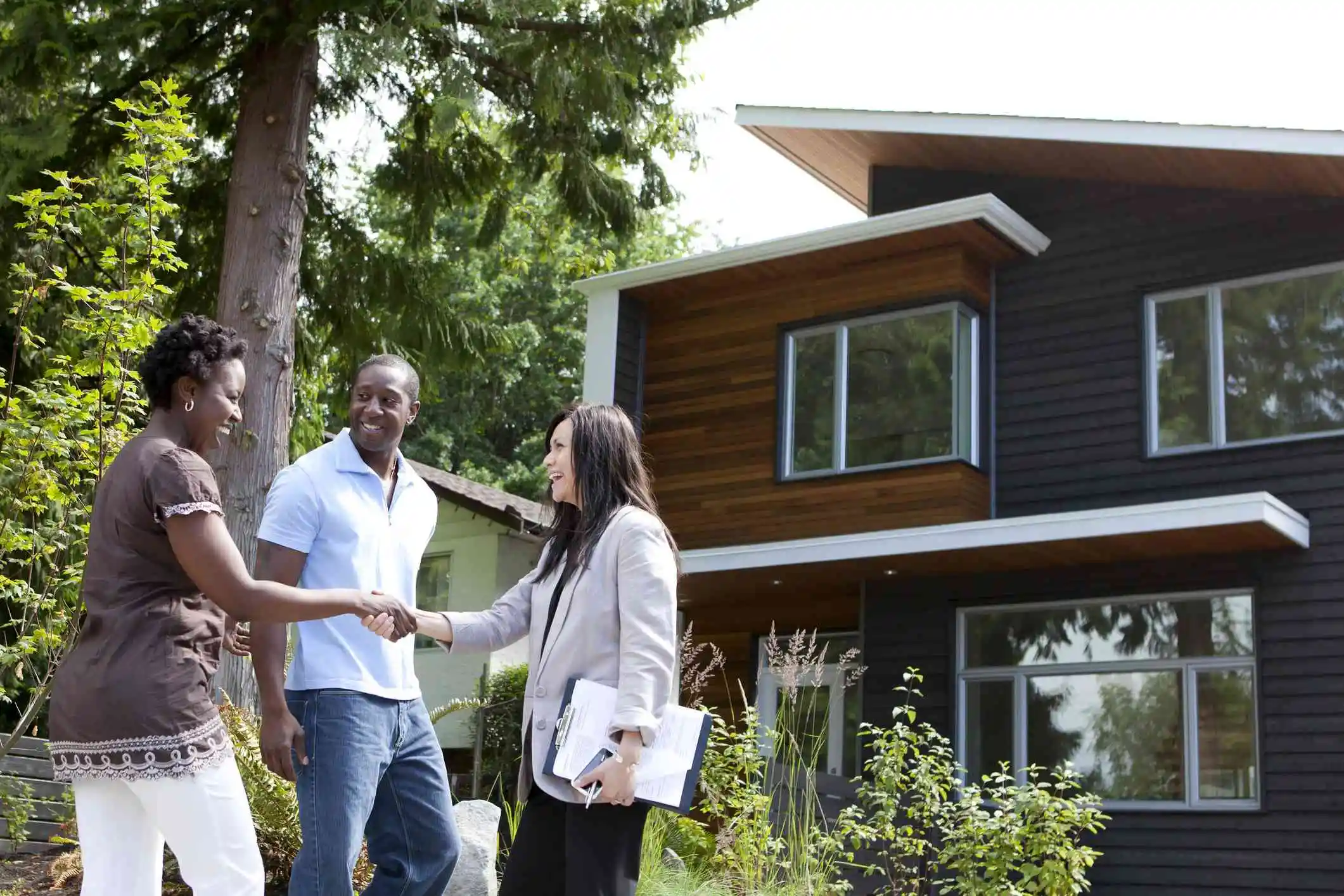 clients and a real estate agent at a house