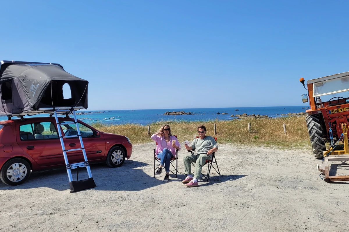 Tente iKamper sur Clio rouge avec couple assis face à la mer bretonne, Kerlouan, Finistère