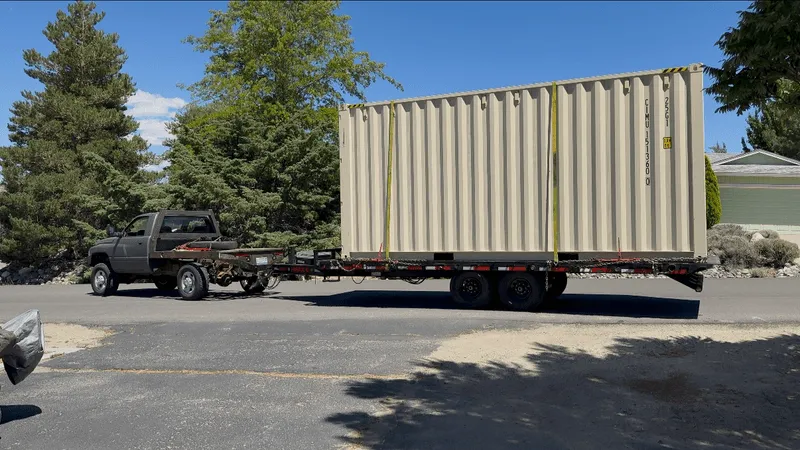 Shipping container carried on an OTG deckover trailer