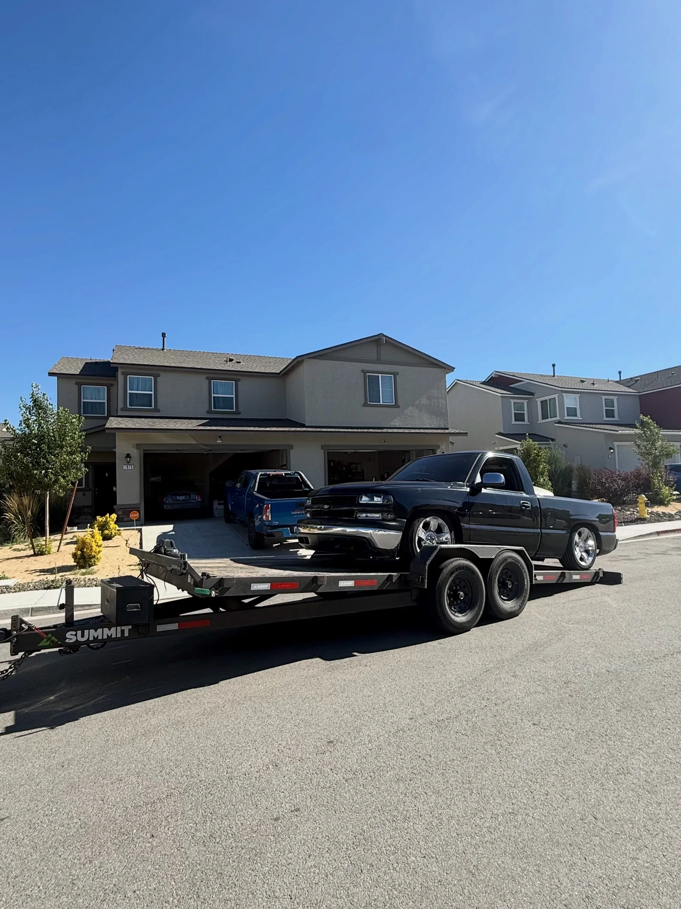 Lowered black pickup loaded on an OTG gravity tilt trailer