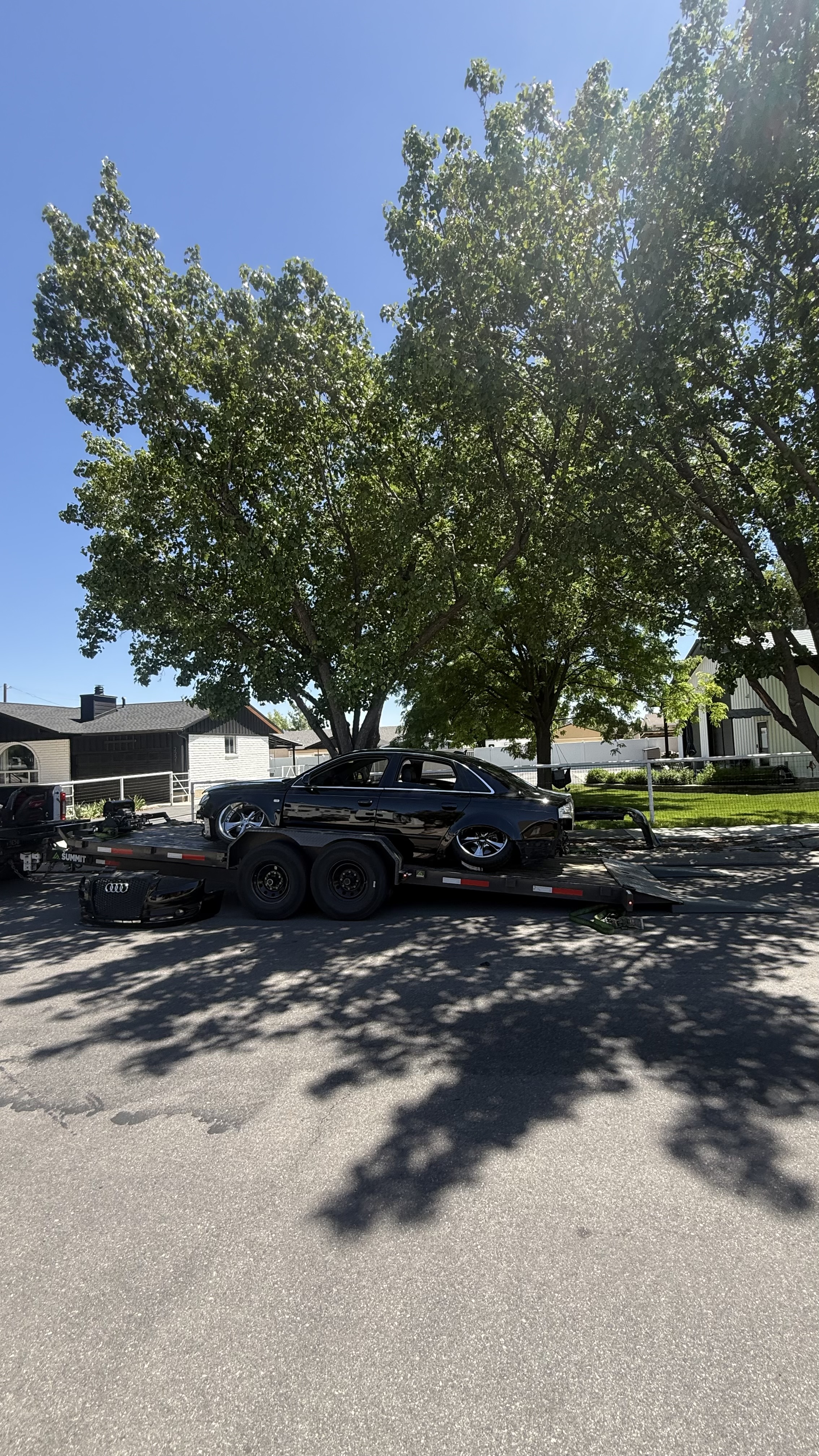 Dark blue pickup truck on a trailer with a yellow sign reading 'RENT ME' and a phone number.