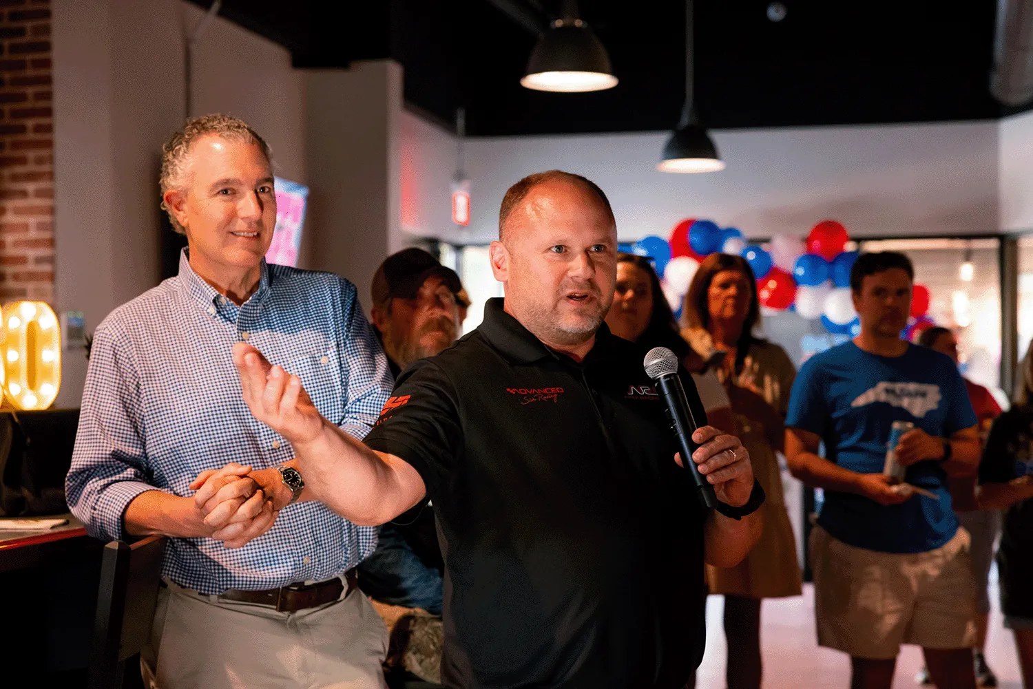 Business leaders speaking at a company event during a brand engagement and community networking session.