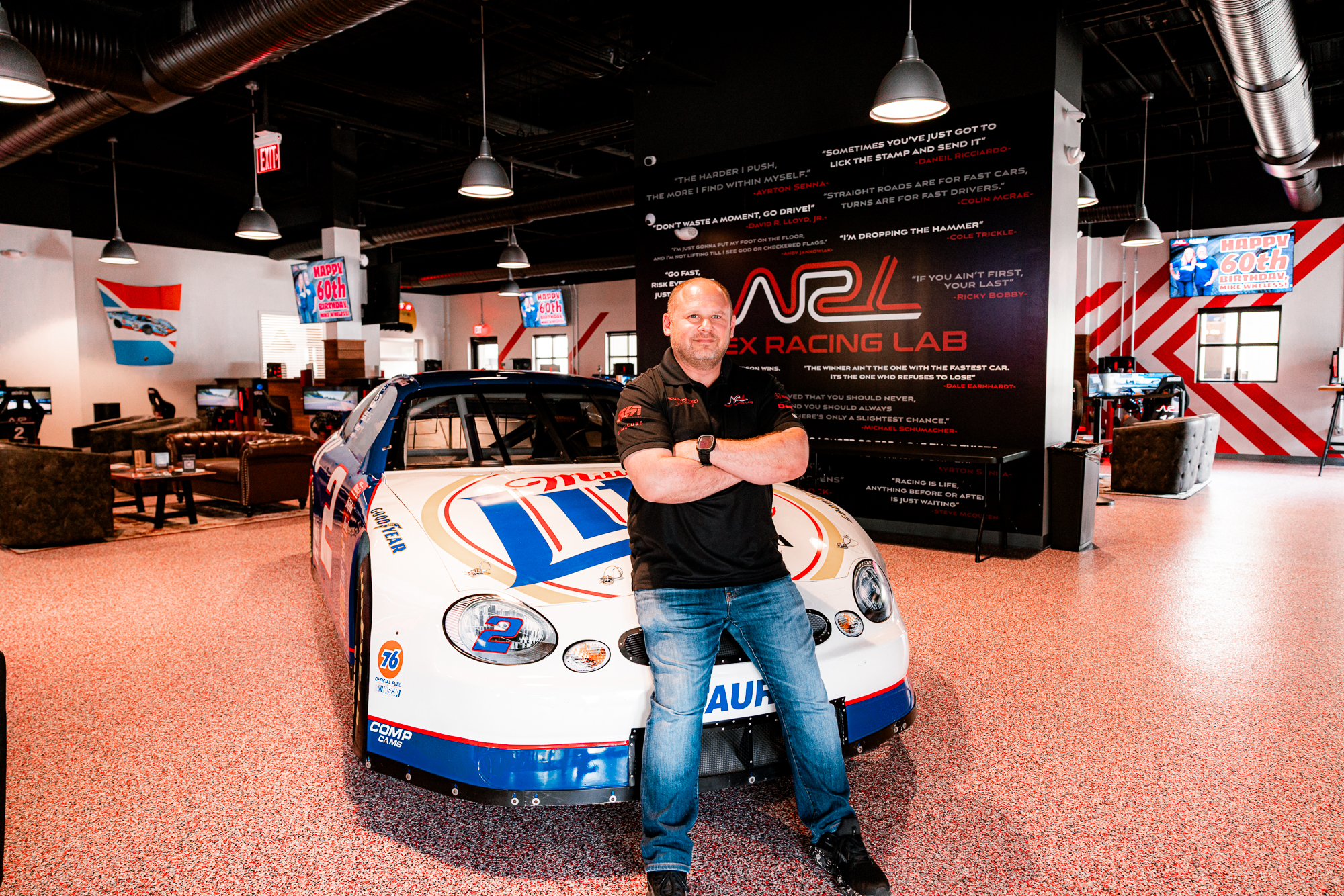 Apex Racing Lab owner standing beside a racing simulator car