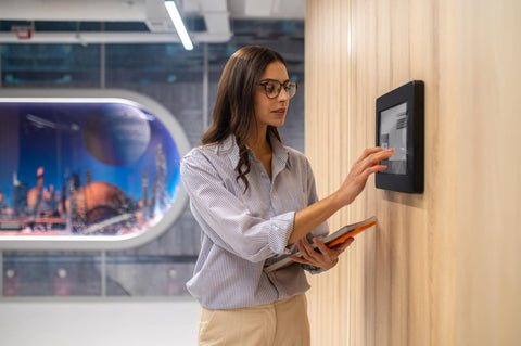Woman touching control panel on wall