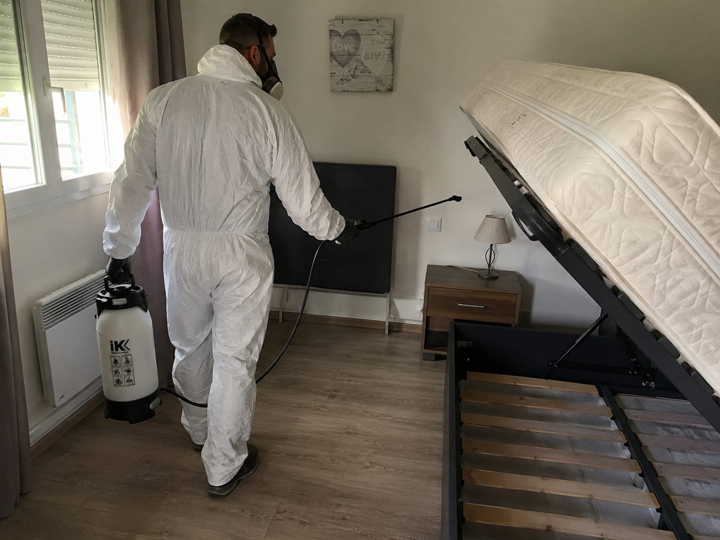 Technicien Certibiocide PropNet34 en combinaison blanche traitant un matelas contre les punaises de lit à Montpellier