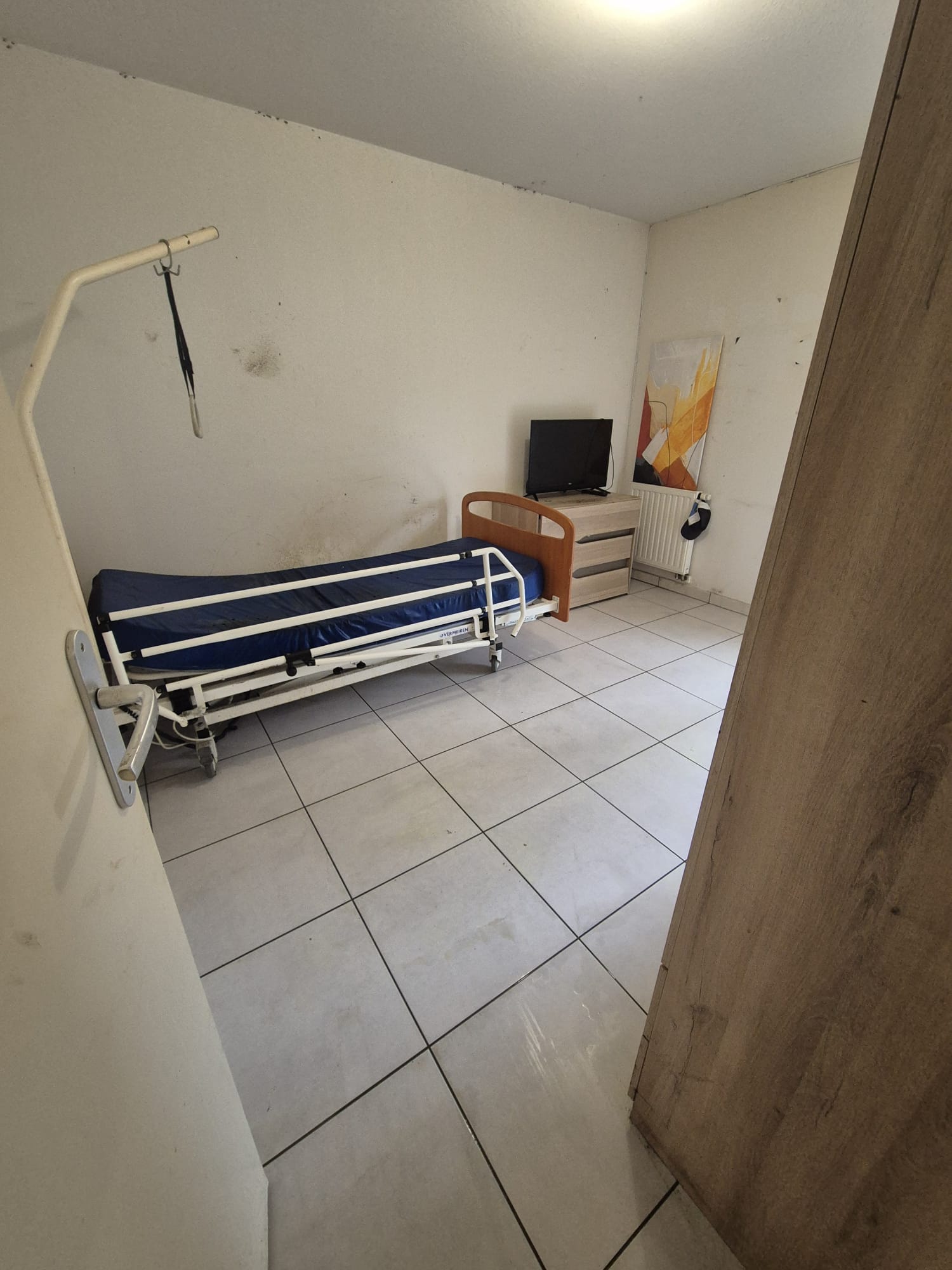 Technicien PropNet34 en combinaison évacuant des sacs lors d'un débarras de logement insalubre