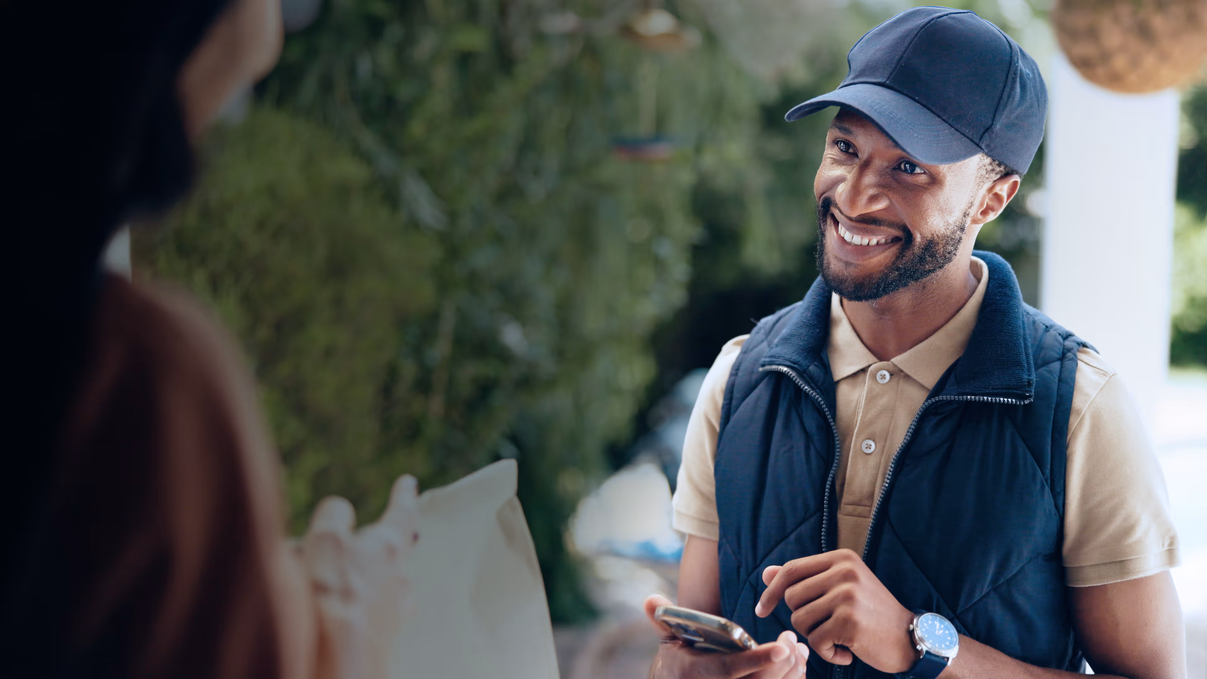 Happy home delivery driver with customer at door with phone for online order, shipment
