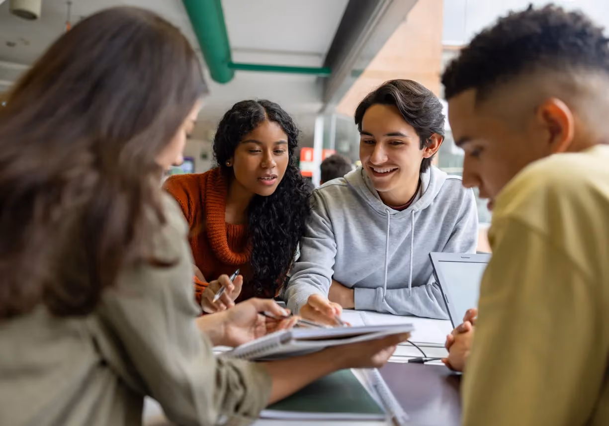 Happy group of students studying together at the library