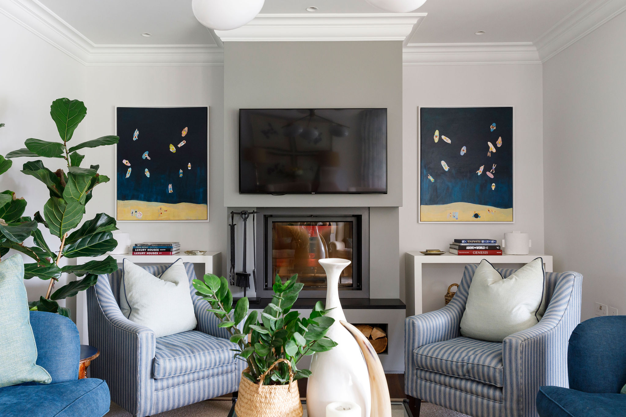 Sussex country home living room styled by Lorna Smith Interiors — contemporary fireplace with blue striped armchairs and statement artwork