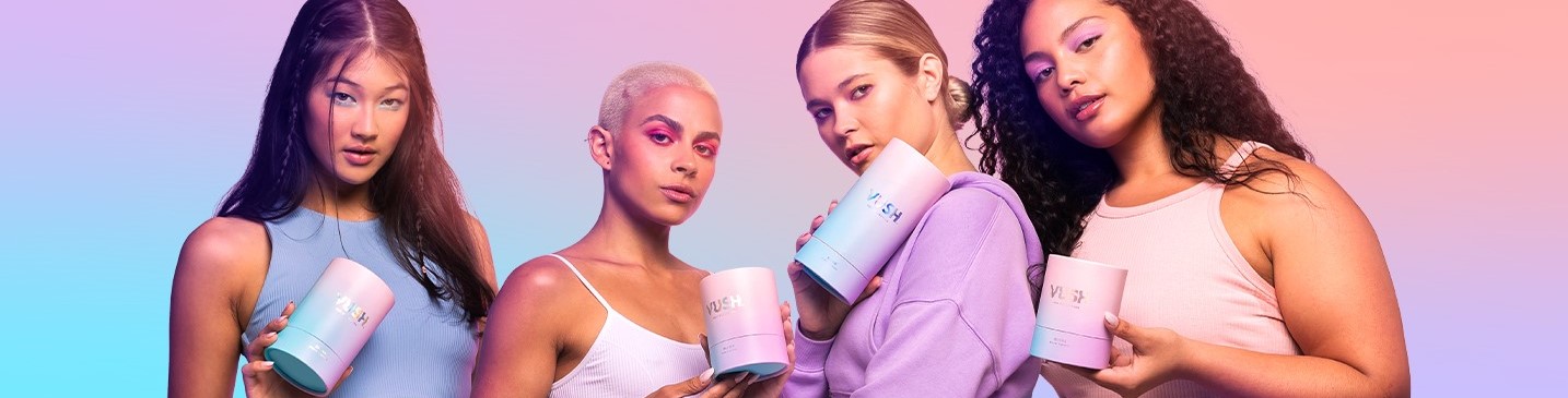 Four people pose confidently against a pastel gradient background, holding cylindrical product containers. They wear casual clothing and vibrant makeup, creating a chic and modern vibe perfect for an eCommerce setting.