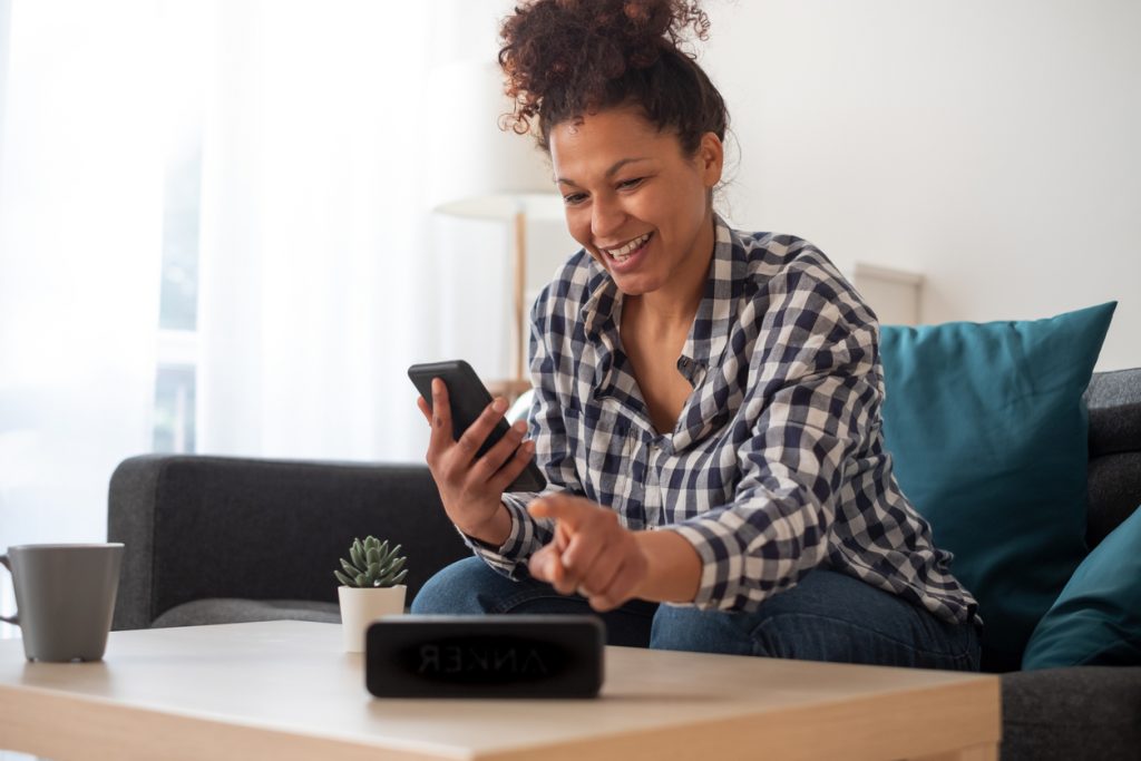 woman-using-phone-and-smart-speaker