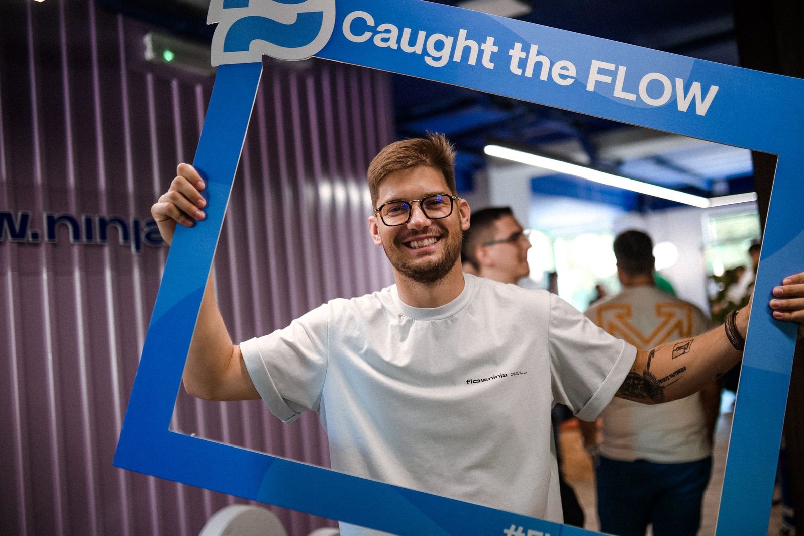 Uroš Mikić smiling through a Caught the Flow photo frame at a Flow Ninja event