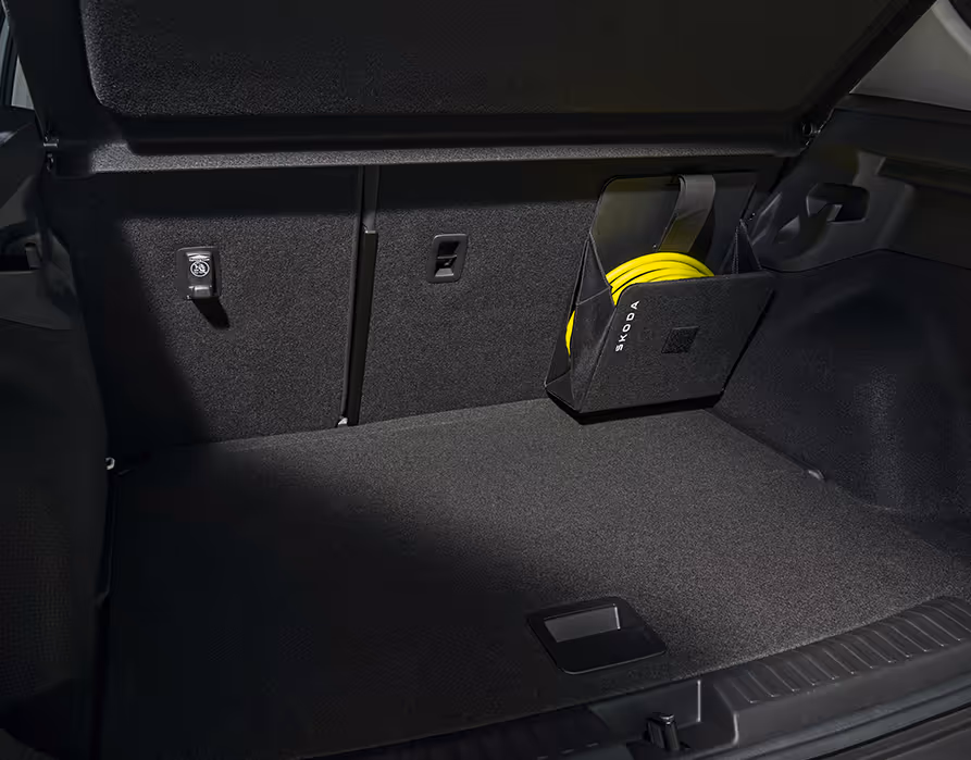 Eine Aufnahme des Gepäckraums. An der Rücksitzlehne ist eine schwarze Tasche mit „ŠKODA“ Schriftzug befestigt, in der ein gelbes Ladekabel verstaut ist.