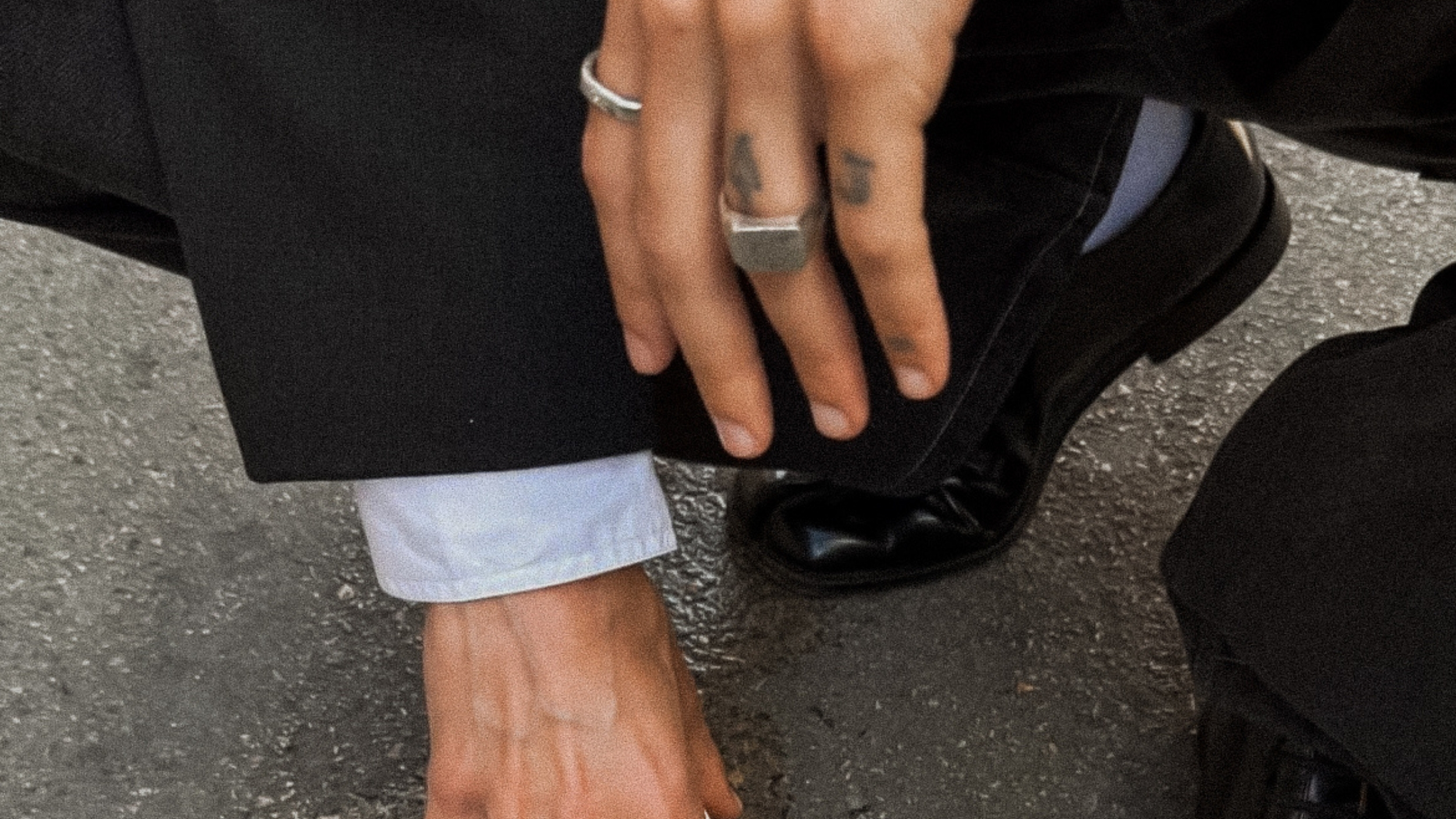 Urbaner, edgy Stilausdruck einer Person mit Tattoos und Silberschmuck für die About-Seite des UNBOTHERED® Studios.