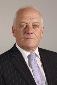 Senior man in formal business suit with pinstriped jacket and lavender tie, professional headshot