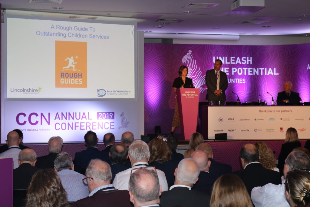 CCN Annual Conference 2019 presentation with speakers on stage and audience members seated below.