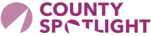 County Spotlight logo with purple circular design and text