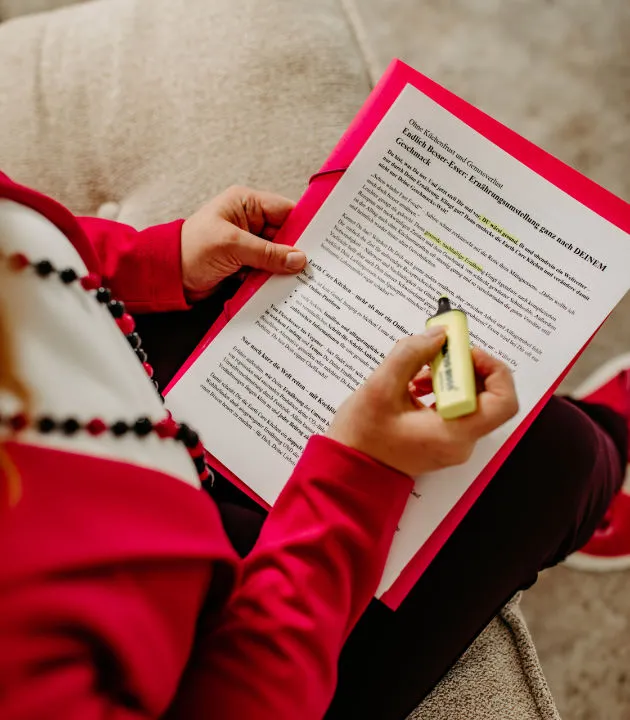 Louisa Hoffschult in a pink blazer highlighting text on a printed document with a yellow marker.