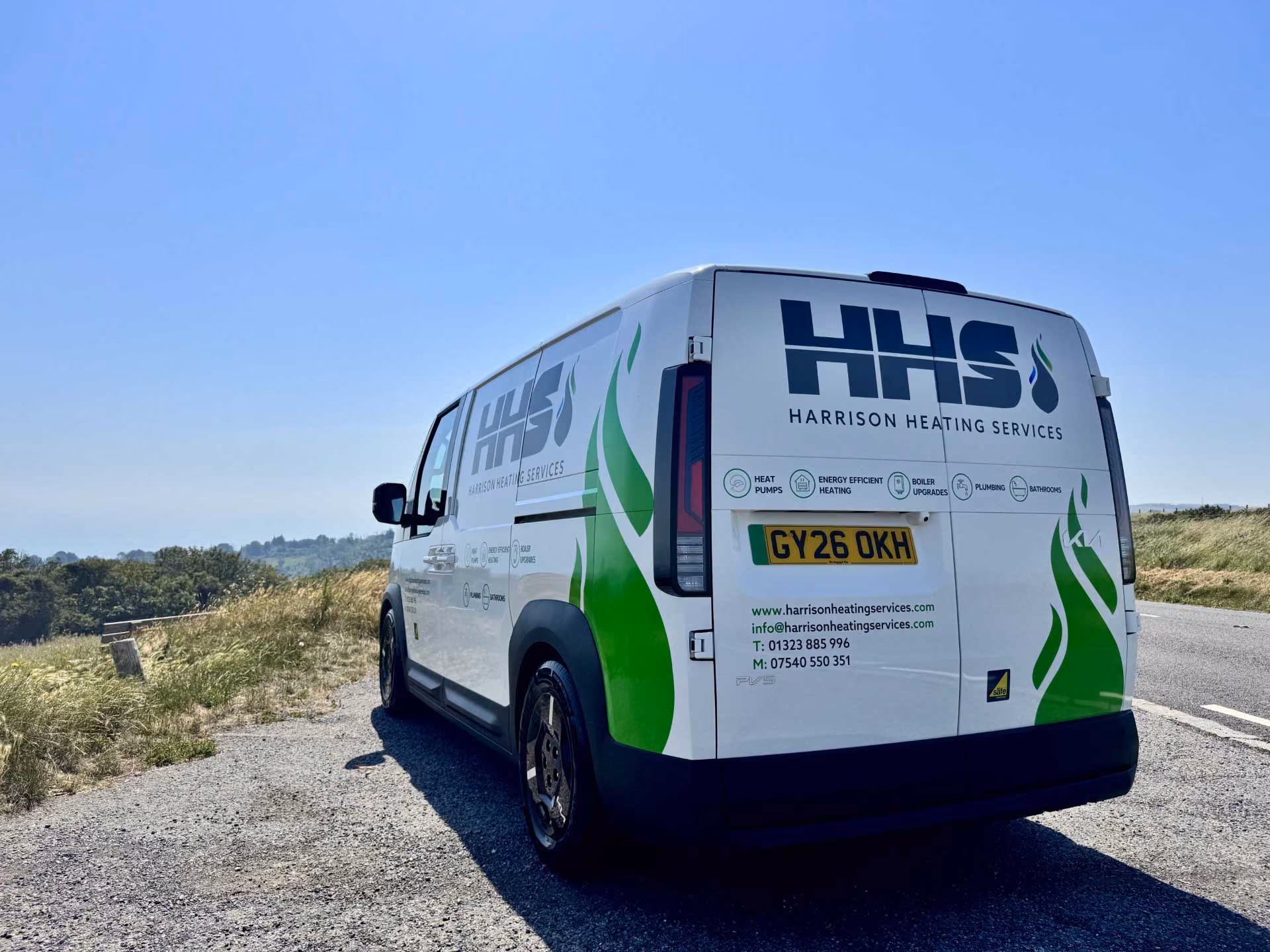 White van parked on roadside, displaying "Harrison Heating Services" logo and contact information.