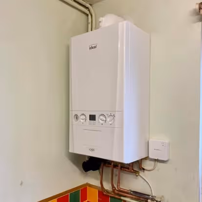 A white wall-mounted boiler with control knobs and a small digital display.