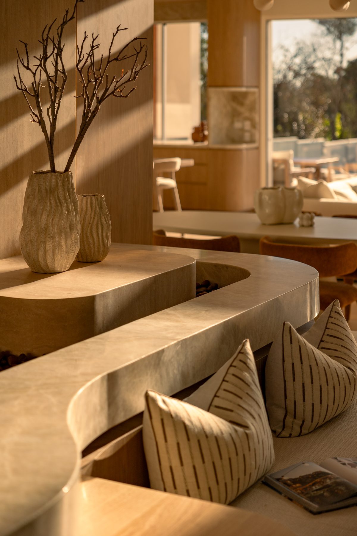 Curved stone feature with striped linen cushions and ceramic vases, Girraween House