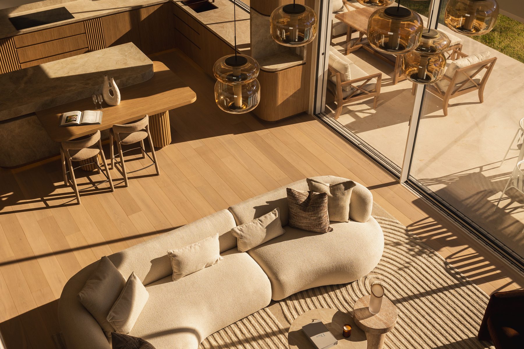 Aerial view of open plan living and kitchen with curved sofa, Girraween House