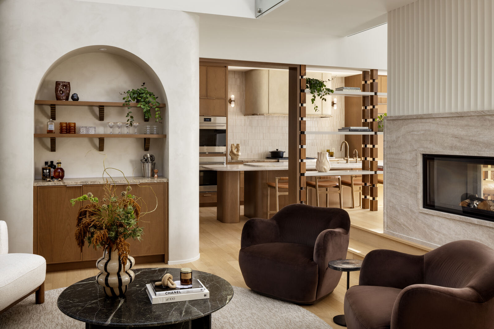 Living room with arched plaster niche, curved brown armchairs and fireplace, Madison Residence