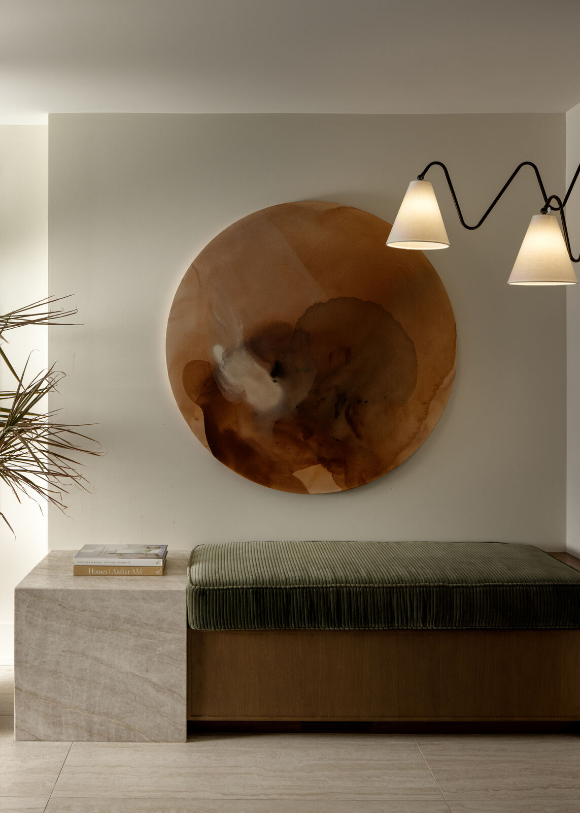 Entry moment with round sculptural artwork, wall sconce and stone bench, Madison Residence