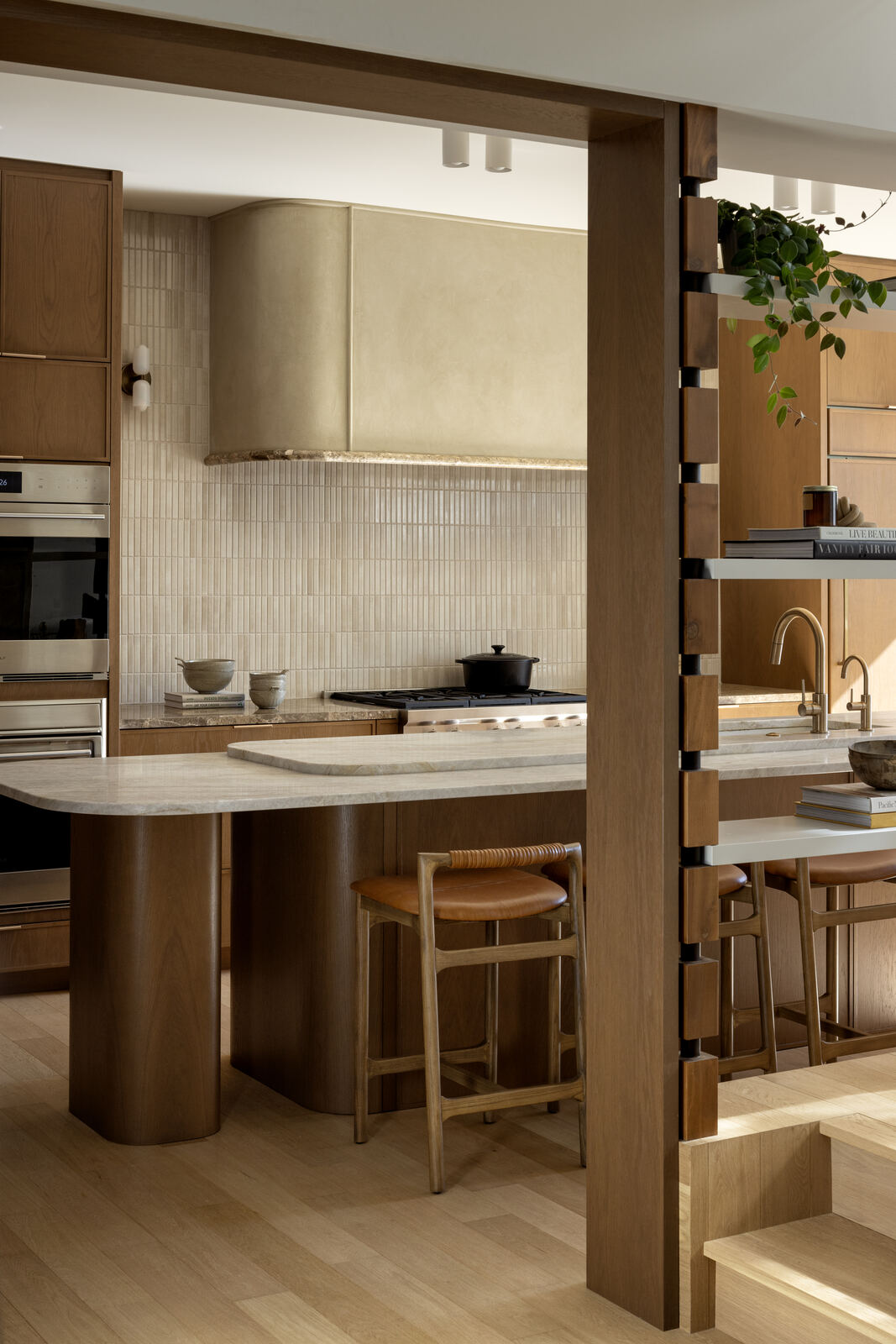 Kitchen with warm oak joinery, stone island and timber screen stair, Madison Residence
