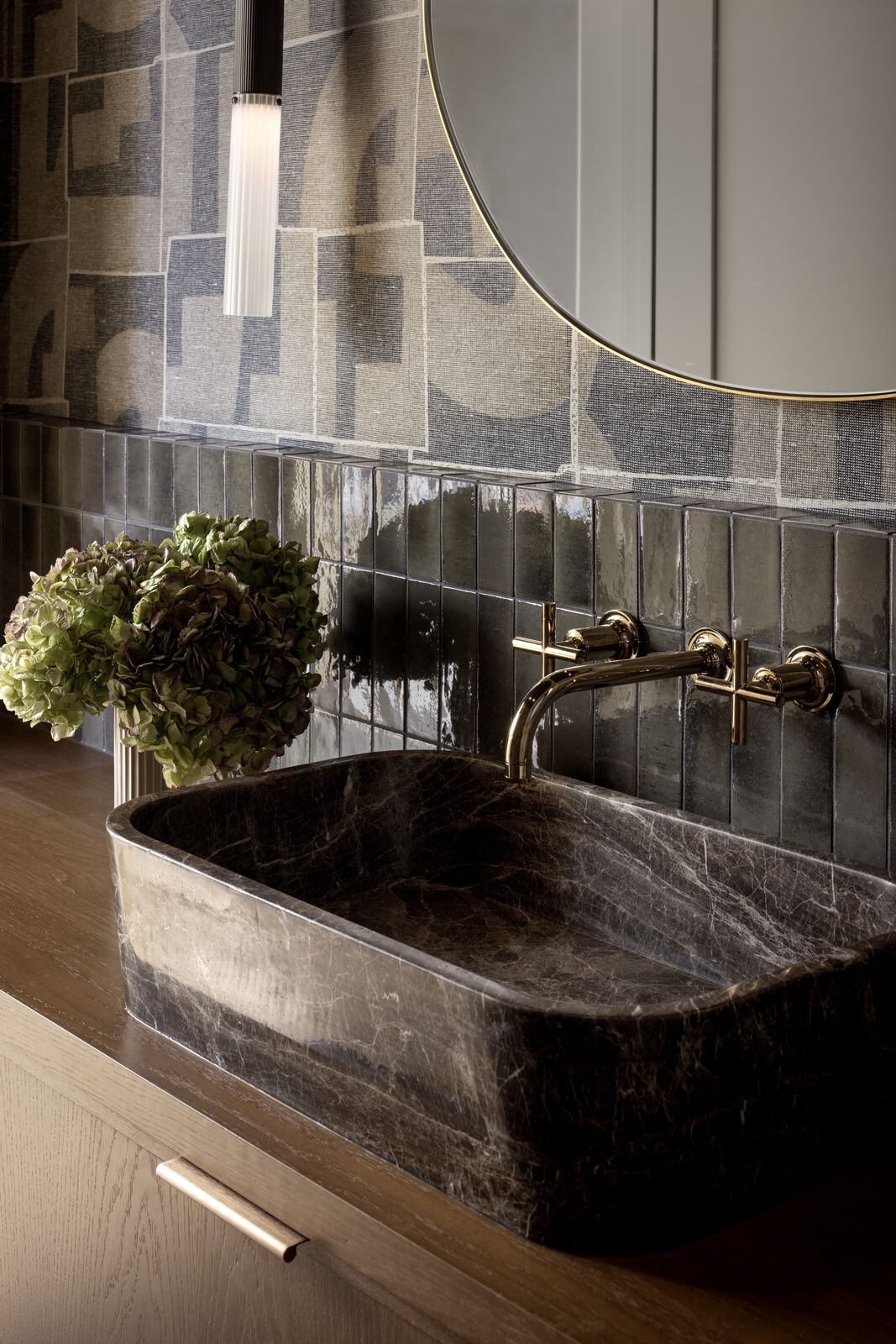 Bathroom detail with carved stone basin, brass tapware and patterned tiles, Madison Residence