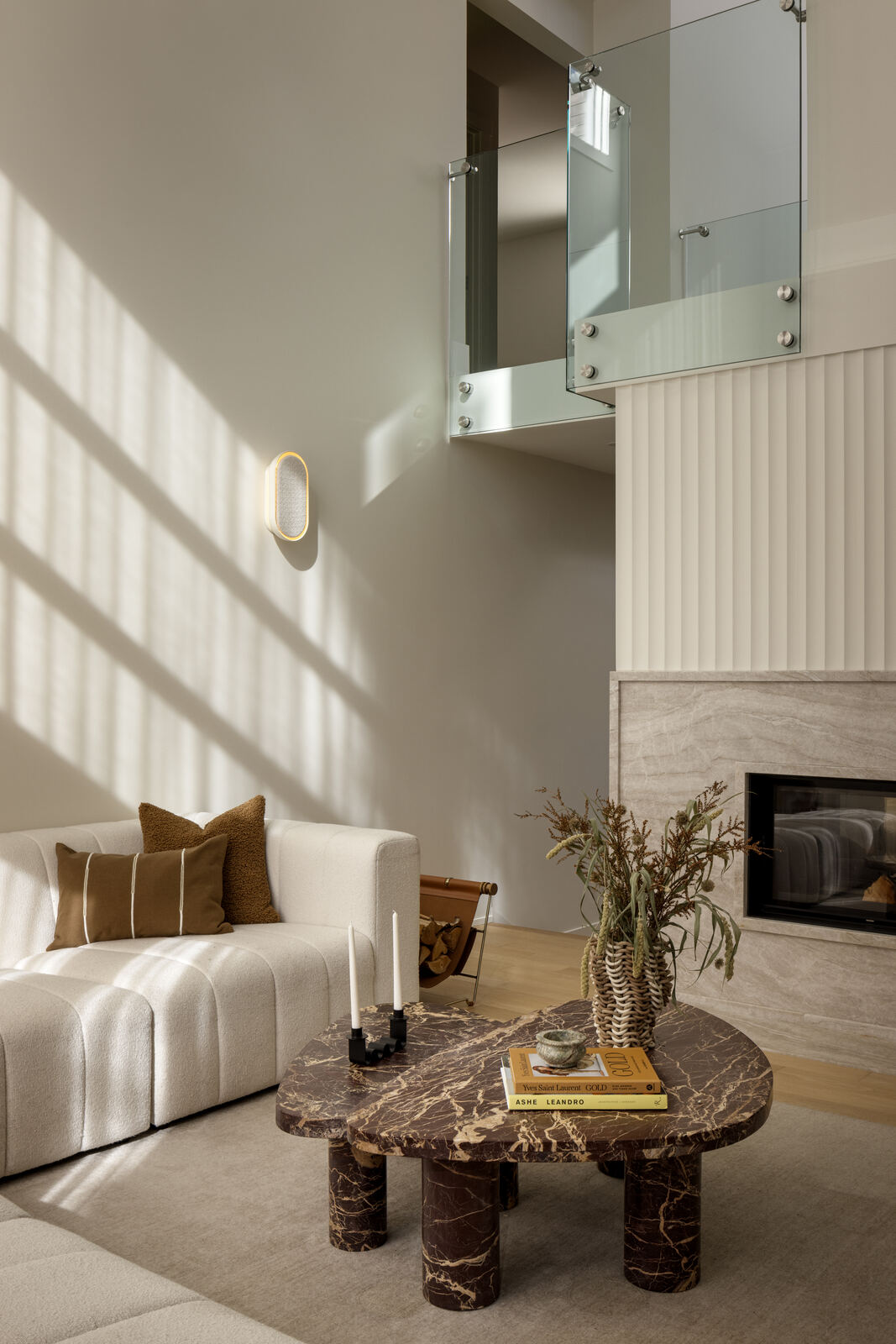 Double height living space with cream sofa, marble coffee table and fireplace, Madison Residence