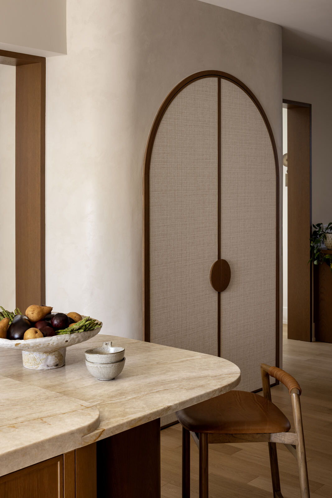 Arched fabric panel doors beside a travertine breakfast bar, Madison Residence