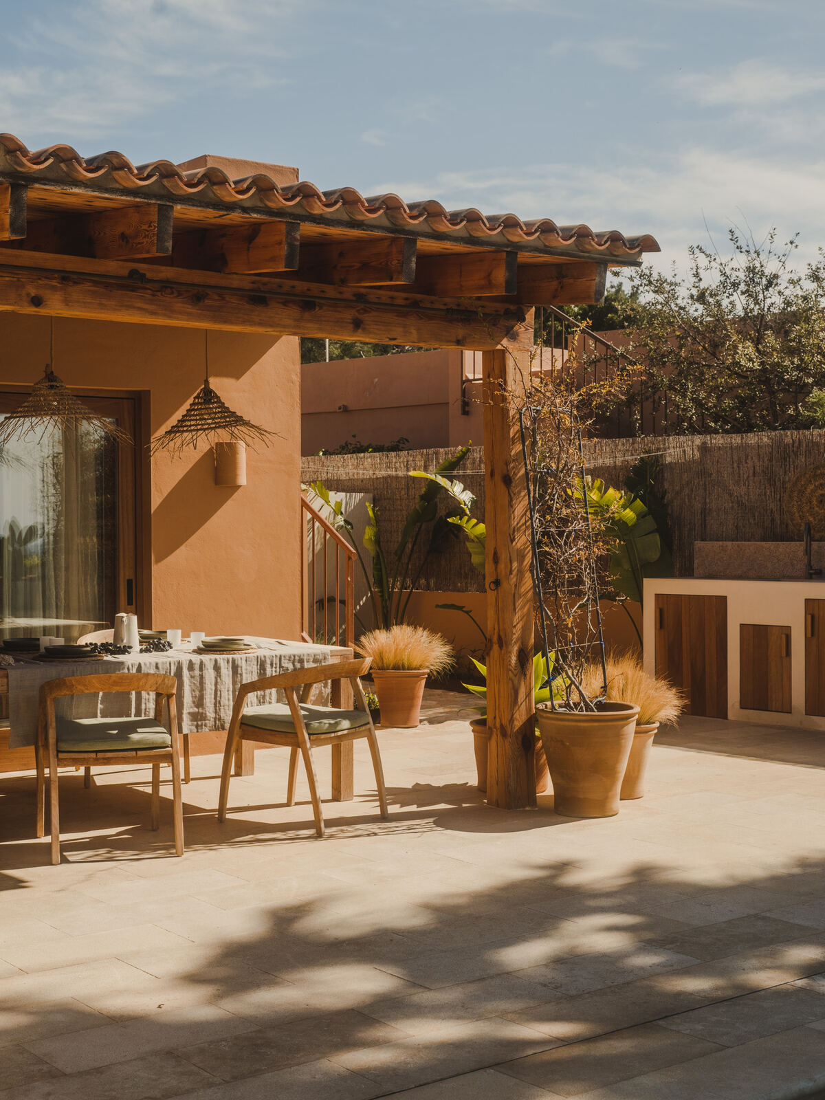 Outdoor dining beneath a timber pergola on the terrace, Casa M
