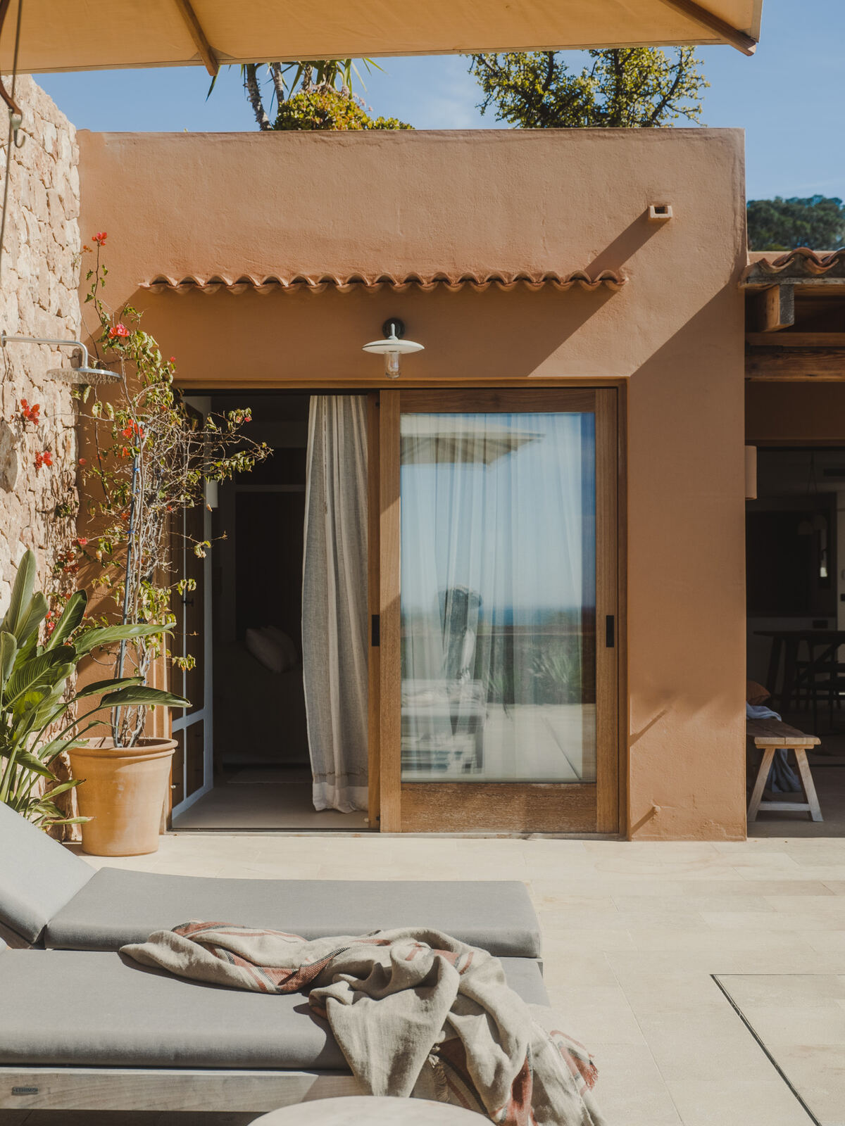 Terracotta facade with linen daybeds beside the pool terrace, Casa M