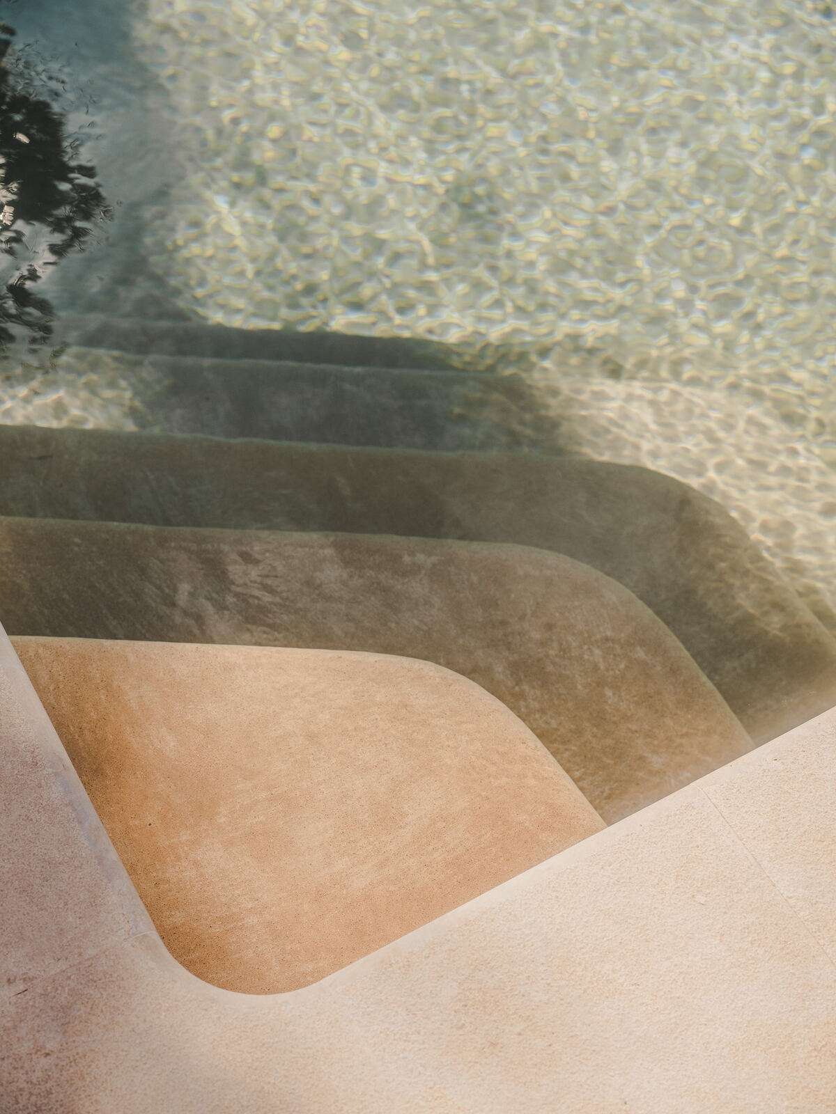 Steps into the pool through clear water, Casa M