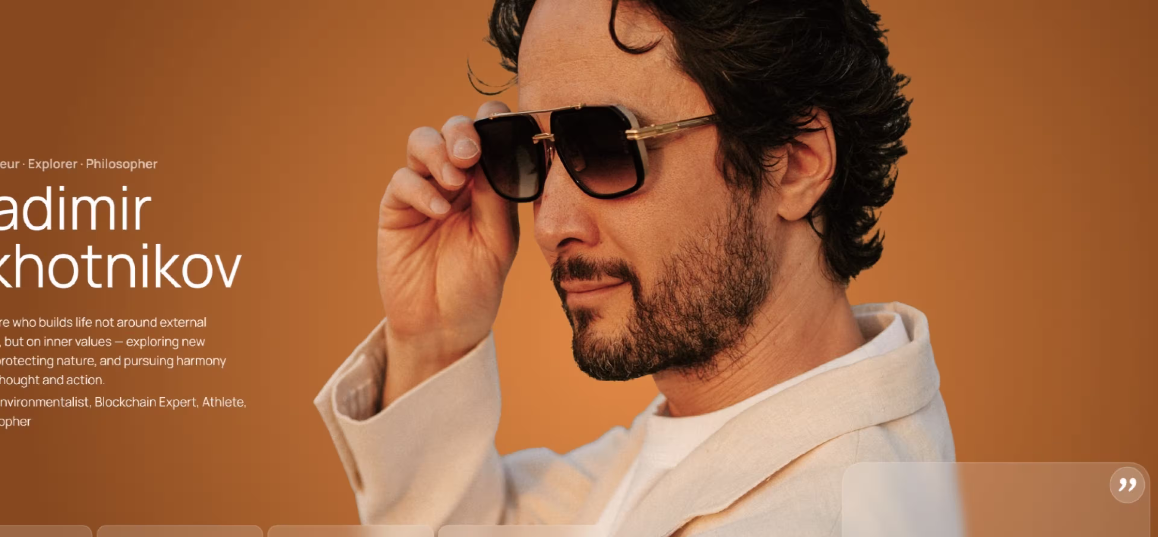 Vladimir Okhotnikov wearing sunglasses and light-colored jacket facing right on orange background.