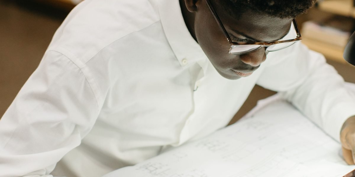 A person deeply focused on studying, using resources to prepare for a certification exam.
