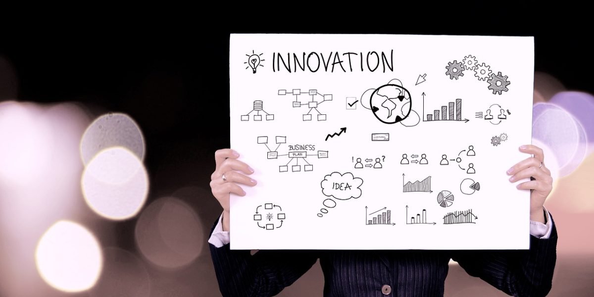 Business leaders actively discussing and strategizing on how to implement AI within their organization, using a whiteboard to visualize their framework.