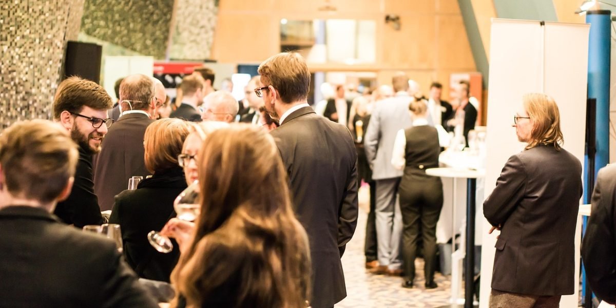 Professionals networking and exchanging ideas at a technology conference, reflecting talent movement.