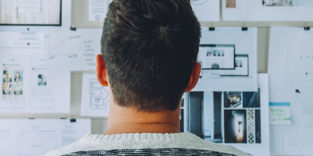 A person deep in thought while mapping out solutions on a whiteboard, representing the adaptation required for new AI threats.