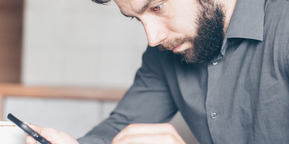 A person appears stressed or overwhelmed while looking at their phone, reflecting the increased anxiety linked to constant digital engagement.