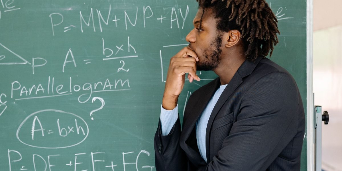 A person reflecting on complex problems, symbolizing the need to rethink traditional approaches to cyber awareness.