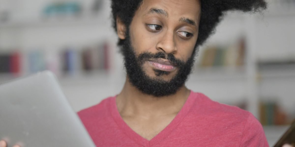 A person looks thoughtfully at a screen, symbolizing the critical evaluation needed for AI-generated information and the erosion of trust.