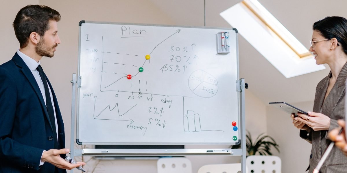 A team of professionals collaborates on a whiteboard, strategizing how to align AI with business intelligence goals.