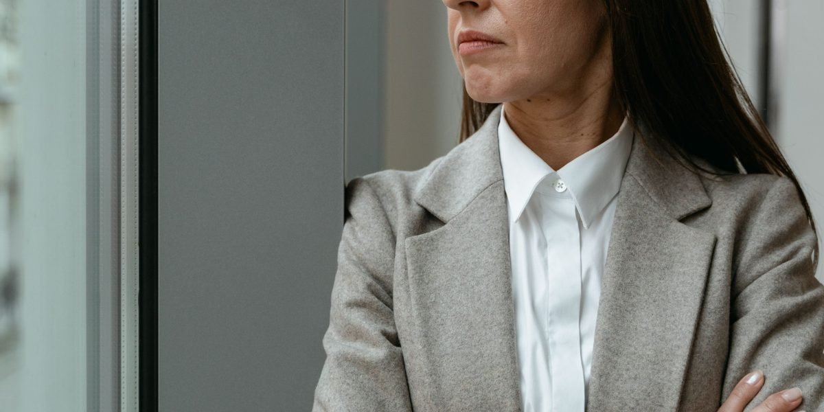 A person looks thoughtfully, contemplating the critical role of network security in maintaining data integrity and public trust for AI-driven organizations.