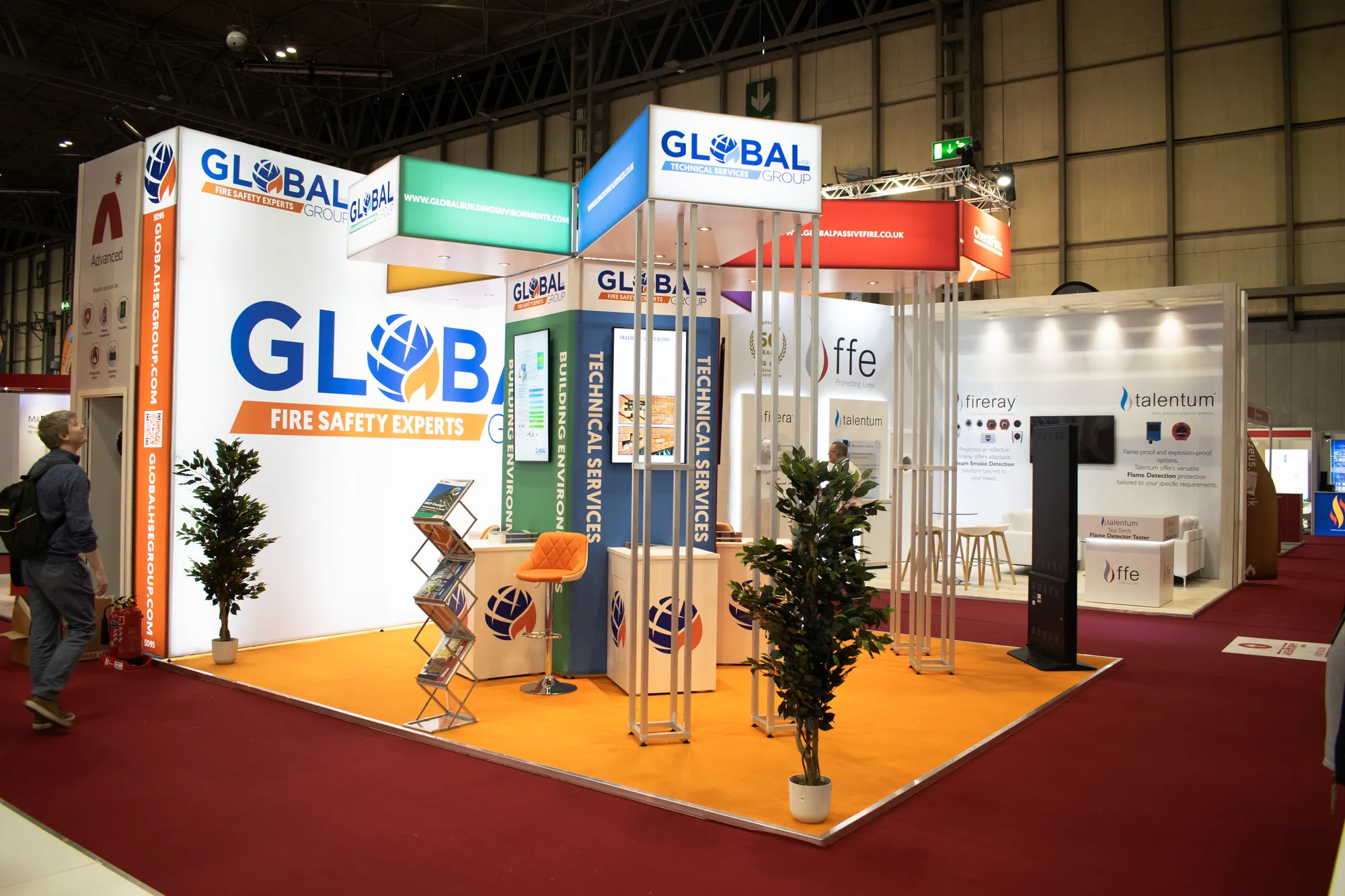 Island modular stand with branded lightbox towers and planting